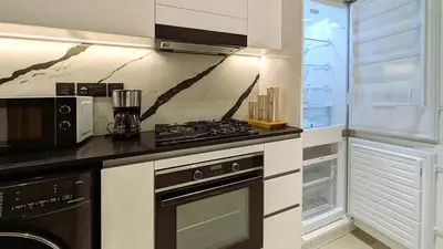 a kitchen with a stove and a microwave at Sleek and Cozy Studio, Private Jacuzzi, Canal View in Dubai