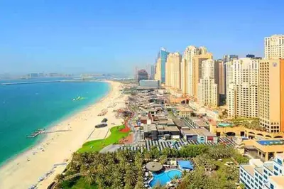 a view of a beach with buildings and the ocean at Bright Apartment with Large Balcony and Water View in JBR in Dubai