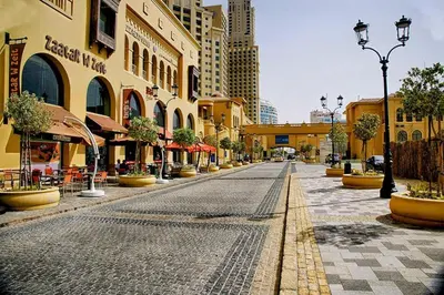 a cobblestone street in a city with tall buildings at Bright Apartment with Large Balcony and Water View in JBR in Dubai