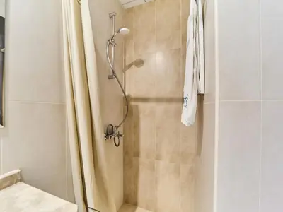 a shower with a shower curtain in a bathroom at Cozy 2BR Canal Residence Sports City in Dubai