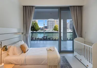 a bedroom with a bed with a view of a balcony at Canal Front Residence 5, Al Wasl - 2 Bedroom with Maids room - Allsopp & Allsopp 02 in Dubai