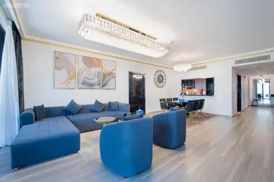 a living room with blue couches and a dining room at Blvd Point-Full Burj Khalifa View-Downtown in Dubai
