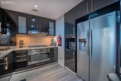 a kitchen with a stainless steel refrigerator and cabinets at Blvd Point-Full Burj Khalifa View-Downtown in Dubai