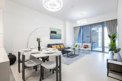 a white living room with a table and chairs at Canal Front Residence 5, Al Wasl - 2 Bedroom with Maids room - Allsopp & Allsopp 01 in Dubai