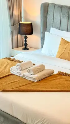 a bed with two towels sitting on top of it at Stylish 1BDR Centrally Located for 4 Persons in Dubai