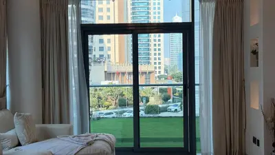 a large window with a view of a city at 1BDR with Huge Balcony Stylish Living in Dubai