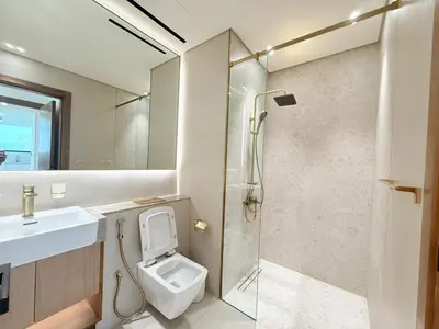 a bathroom with a shower and a toilet and a sink at Binghatti Gardenia 2BHK in JVC in Dubai