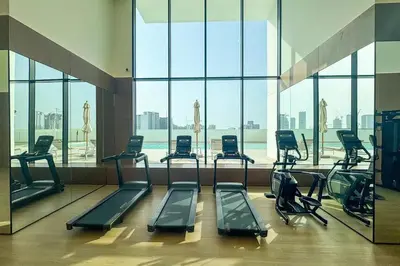 a gym with a bunch of treadmills in a building at Binghatti Gardenia 2BHK in JVC in Dubai