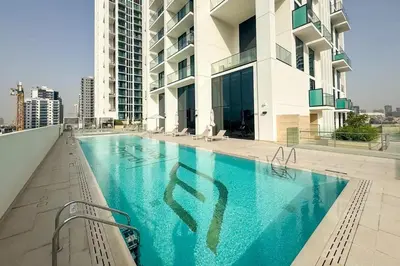 a swimming pool on the side of a building at Binghatti Gardenia 2BHK in JVC in Dubai