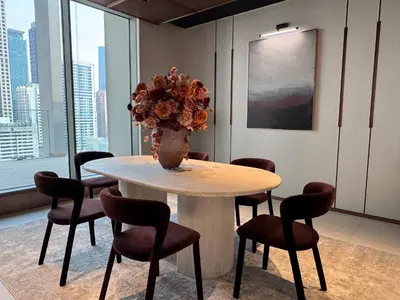 a table with chairs and a vase with flowers on it at Boutique-Style Luxury Studio in Hyde Walk in Dubai