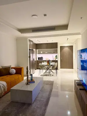 a living room with a couch and a tv and a table at Ultra Luxury Emaar Beachfront Flat With Private Beach in Dubai
