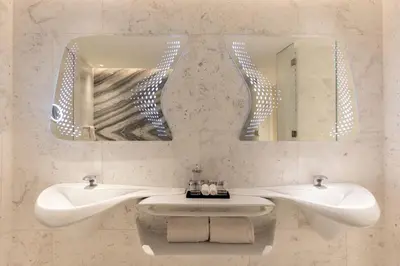 a bathroom with two sinks and two mirrors at The Opus Residences 1 Bedroom in Dubai