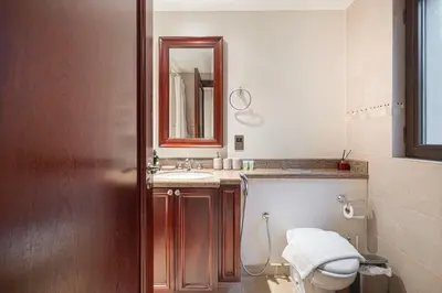 a bathroom with a toilet and a sink and a mirror at Massive 2,000 sqft 1BR with Private Terrace & BBQ in Dubai