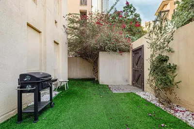 a grill sitting in a yard next to a building at Massive 2,000 sqft 1BR with Private Terrace & BBQ in Dubai
