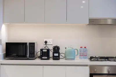 a kitchen counter with a microwave and appliances on it at Modern 2BR, Burj & Fountains View, Dubai Mall 2 Minutes Walk in Dubai
