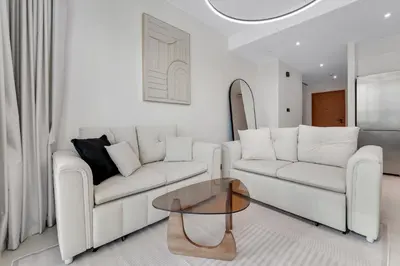 a living room with two white couches and a glass table at VIDA Marina Best Location NEW in Dubai
