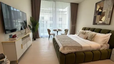 a bedroom with a large bed and a television at Modern Studio JVC I Sleeps 3 I Fully Furnished in Dubai