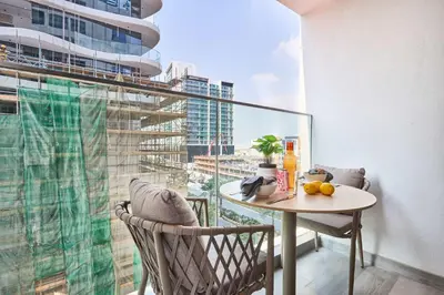 a balcony with a table and chairs and a large window at Frank Porter - Concept Residences in Dubai