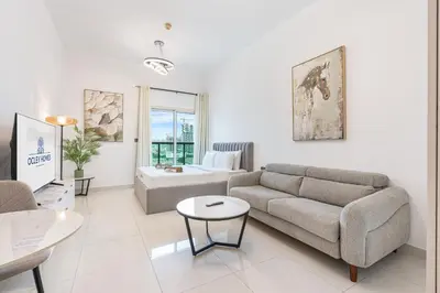 a living room with a couch and a table at Elegant Minimal Studio with Balcony in Dubai