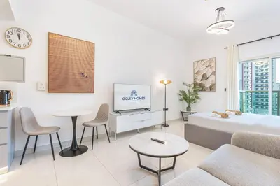 a living room with a couch and a tv at Elegant Minimal Studio with Balcony in Dubai