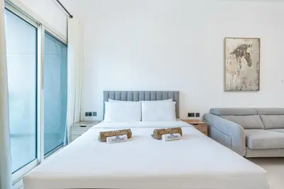 a bedroom with a bed and a couch at Elegant Minimal Studio with Balcony in Dubai