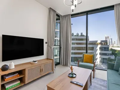 a living room with a flat screen tv and a large window at Luxury 1BR Featuring Guest - Study Room-SOBHA Waves in Dubai