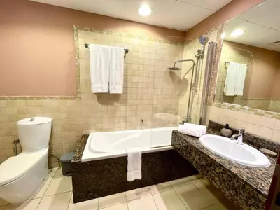 a bathroom with a tub and a toilet and a sink at Specious apartment in Sadaf 7 with Marina Views and Beach Access in Dubai