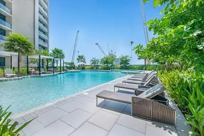 a swimming pool with benches next to a building at Stylish 2BR Canal Views, High Floor in Dubai