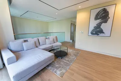 a living room with a white couch and a glass table at Exquisite Jumeirah Bay Island Retreat 3 BR plus maids room in Dubai