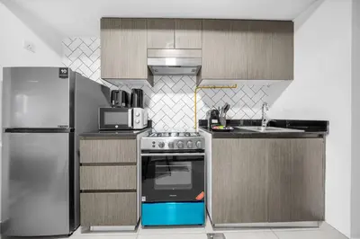 a kitchen with a stove and a refrigerator at Stylish Bella Rose Stay Pool & Gym in Dubai