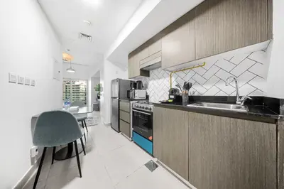 a kitchen with a sink and a stove top oven at Stylish Bella Rose Stay Pool & Gym in Dubai