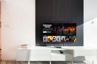 a living room with a tv on a wall at Luxury 1BR Lake View Near Metro & Marina in Dubai