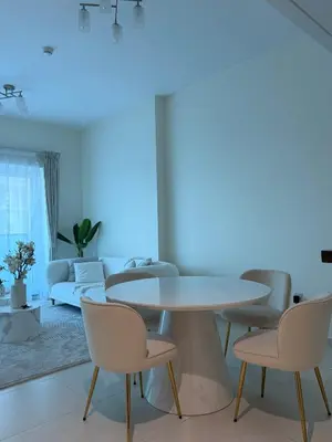 a living room with a table and chairs at Orchid residence 1BHK apartment in Dubai