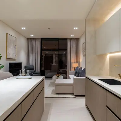 a kitchen and living room with a couch and a table at Brand new apartment with luxury furniture in JVC in Dubai