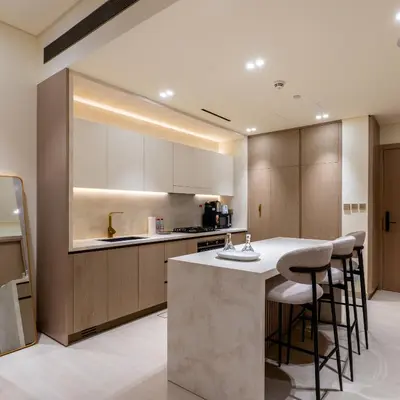 a kitchen with a counter and some stools at Brand new apartment with luxury furniture in JVC in Dubai