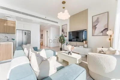a living room with blue and white furniture and a kitchen at Panoramic Sea View, Offering Direct Access to Beach, Three Bedrooms and Assistant Room - Beach Vista Tower 2 by Deluxe Holiday Homes in Dubai