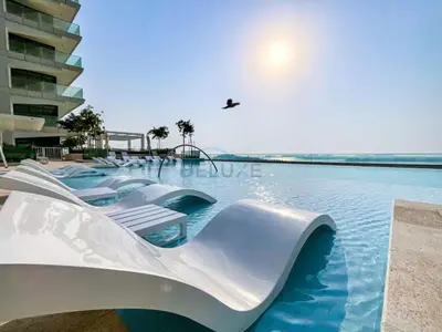 a water slide in a swimming pool at Panoramic Sea View, Offering Direct Access to Beach, Three Bedrooms and Assistant Room - Beach Vista Tower 2 by Deluxe Holiday Homes in Dubai