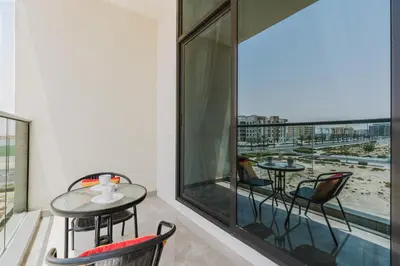 a balcony with tables and chairs and a large window at RH-Smart Studio Near Expocity & Al Maktoum Airport in Dubai