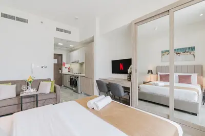a bedroom with a bed and a living room at RH-Smart Studio Near Expocity & Al Maktoum Airport in Dubai