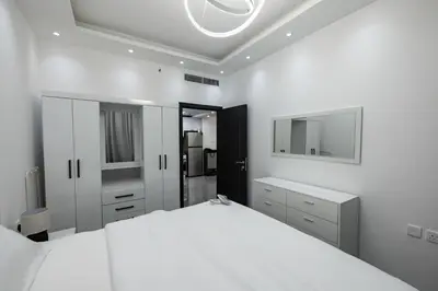 a white bedroom with a large bed and a mirror at Dubai Marina - 1 BHK Elegant & Modern Apartment in Dubai