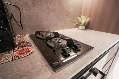 a stove top oven sitting on top of a kitchen counter at Stylish modern studio near Miracle Garden with Gym, Pool and Padel court in Dubai