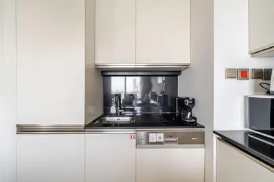 a kitchen with white cabinets and a sink at Highest 1BR in JW Marriott Marina with Marina Views in Dubai