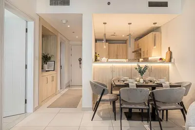 a kitchen and dining room with a table and chairs at Seven Palm! Rooftop Infinity Pool with Great View! Private Beach Access! in Dubai