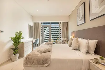 a bedroom with a large white bed and a window at Seven Palm! Rooftop Infinity Pool with Great View! Private Beach Access! in Dubai