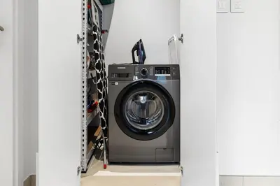 a washer and dryer in a laundry room at Modern 1BR in Jadeel 2 MJL in Low Floor in Dubai