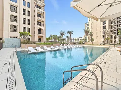 a large swimming pool with lounge chairs and an umbrella at Modern 1BR in Jadeel 2 MJL in Low Floor in Dubai