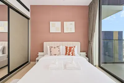 a bedroom with a white bed and a window at Golden Stays - Chic 1BR Oasis Serene & Private in Dubai