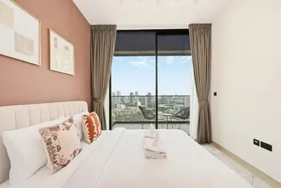 a bedroom with a white bed and a large window at Golden Stays - Chic 1BR Oasis Serene & Private in Dubai