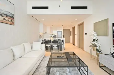 a living room with a white couch and a glass table at Golden Stays - Chic 1BR Oasis Serene & Private in Dubai