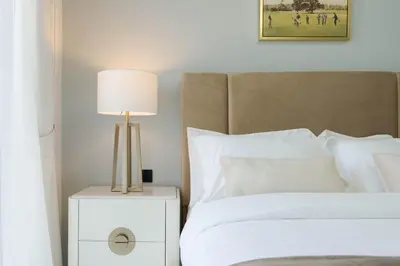 a bedroom with a bed with a lamp on a night stand at KeyRock Living - Luxury Apartment with Pool & Gym in Dubai
